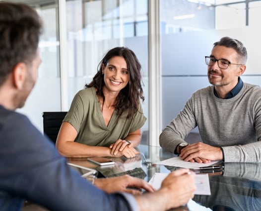 smiling couple getting advice from an attorney